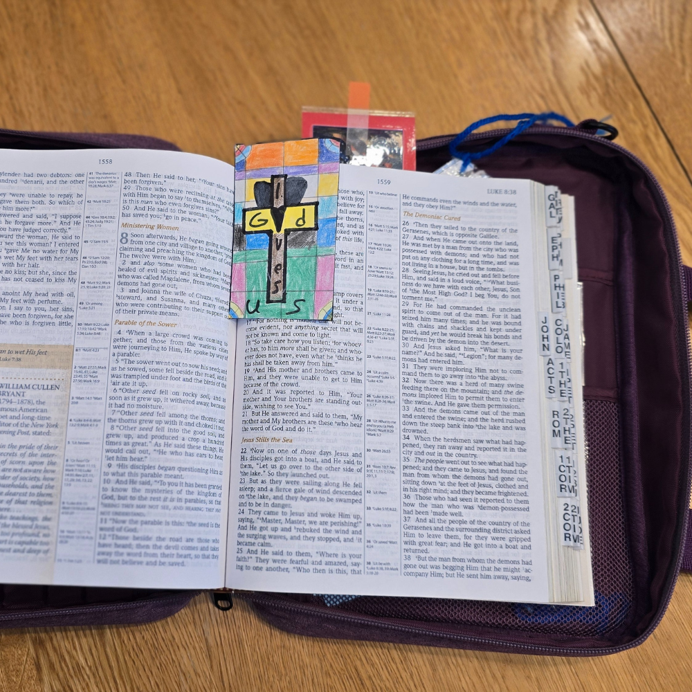 Open Bible with colorful bookmark on a wooden surface